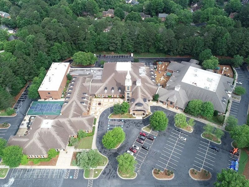 A bird 's eye view of a church with parking lot.