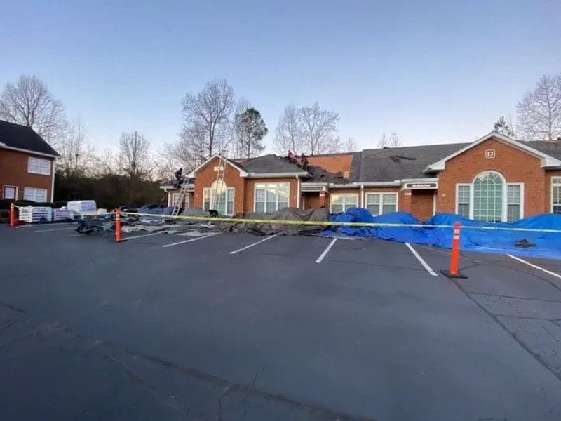 A large parking lot with orange cones in front of it.